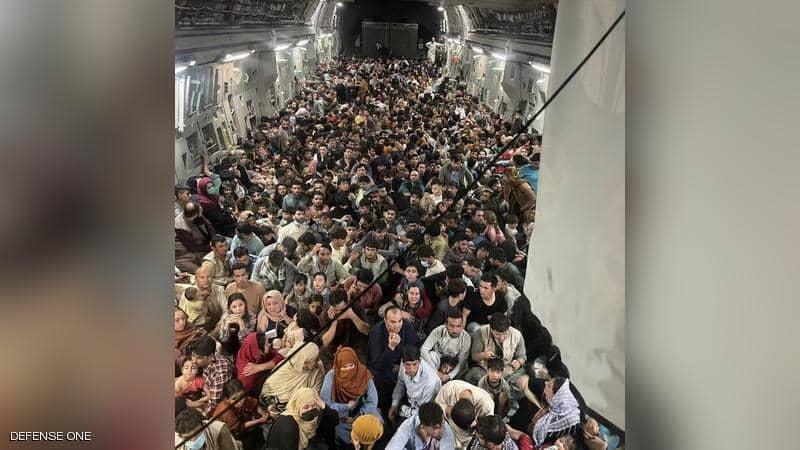 المئات "محشورون" في طائرة عسكرية.. ما قصة الصورة الغريبة؟