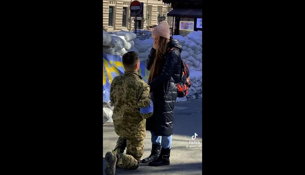 جندي أوكراني يطلب يد حبيبته قرب المتاريس الرملية