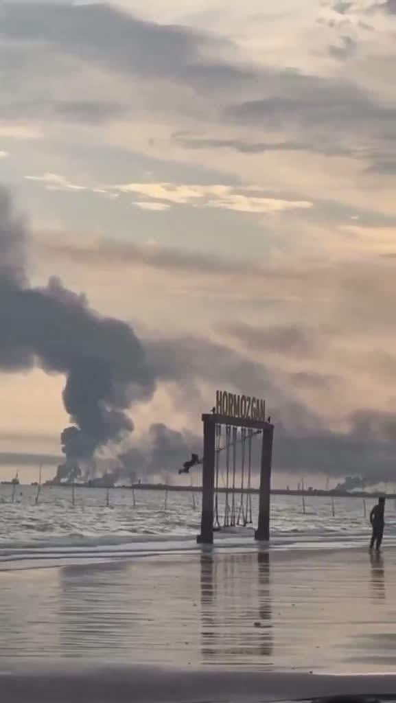 فتاة إيرانية تتأرجح بلا مبالاة بينما تحترق قواعد الحرس الثوري
